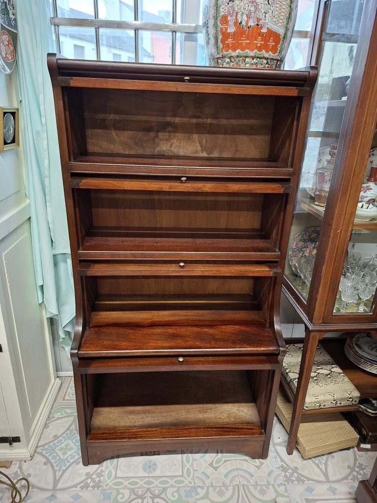Mahogany Stacking Barristers Bookcase, with 3 compartments with glazed and bevelled up and over glass doors. Small original knobs. Bottom compartment fitted with Up and Over Solid Door.
Very Good Condition. Measures 28" wide
by 55" high, 11.75" deep