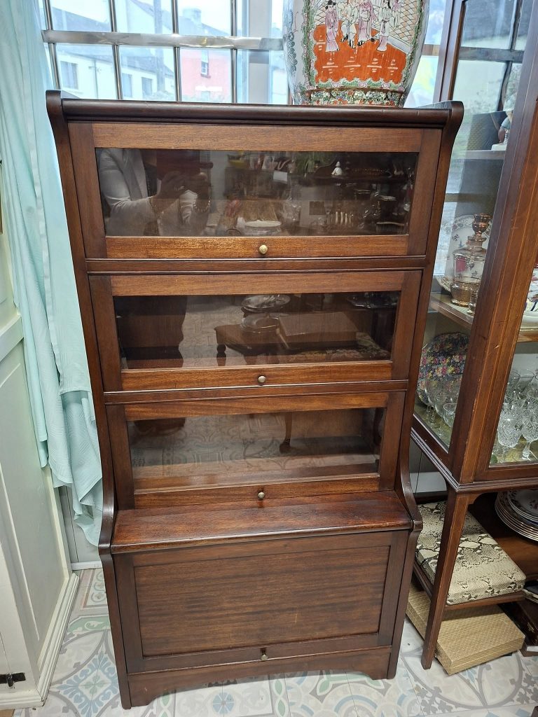 Mahogany Stacking Barristers Bookcase, with 3 compartments with glazed and bevelled up and over glass doors. Small original knobs. Bottom compartment fitted with Up and Over Solid Door.
Very Good Condition. Measures 28" wide
by 55" high, 11.75" deep