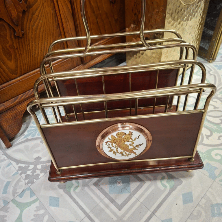 Antique Edwardian Mahogany and Brass Newspaper/
Magazine Rack. Cherub plaque detail on both sides. Standing on 4 bun brass feet. Very good condition
Measures 15" wide by 19" high, 9.5" deep