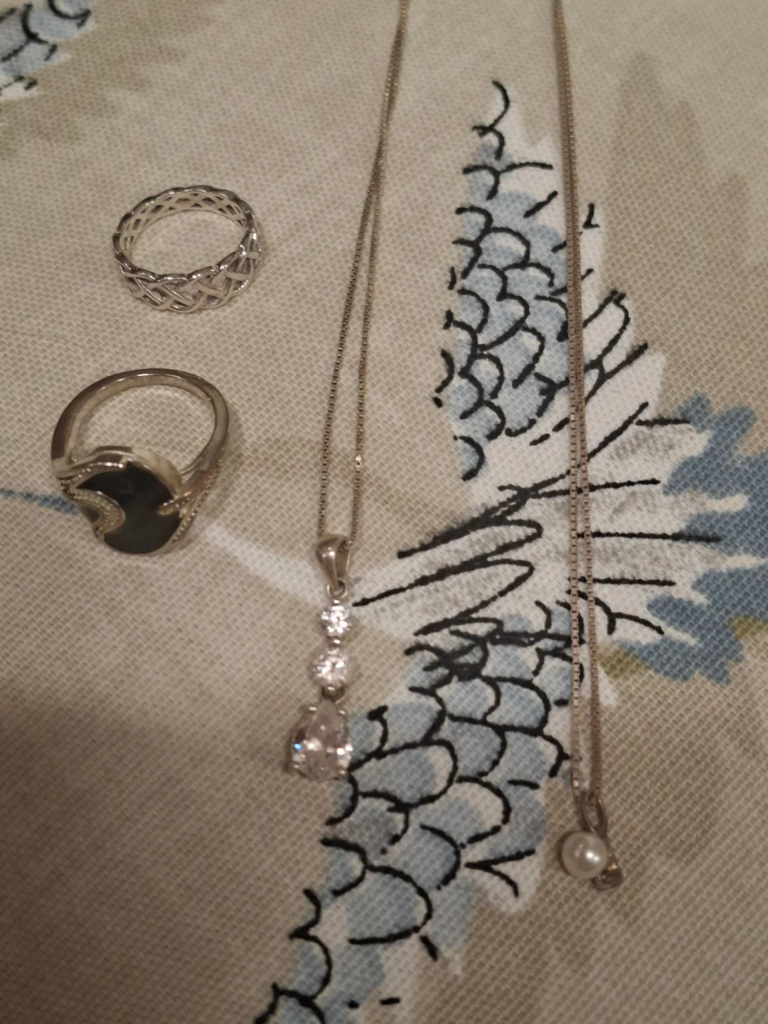 Sterling silver pendants, one set with pearl and one set with zirconia. 10" drop on both.
Two silver rings. 
All in excellent condition.