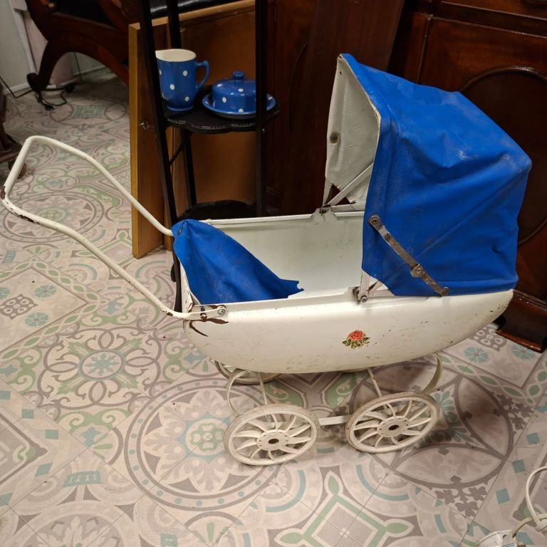 Little Triang Dolls Pram c.1960s. Made in Ireland. Needs small bit of attention. All pieces intact and undamaged. Measures 27" from handle to back. 25" high