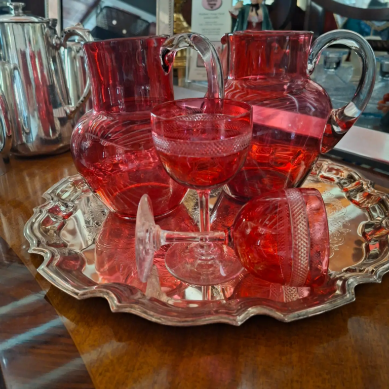 Pair of Victorian Cranberry Water Jugs and Pair of unusual Cranberry Wine Glass. Jugs measure 7" high. Wine glass measures 5" high. Excellent condition.